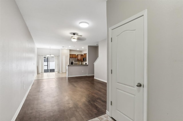 unfurnished living room with light hardwood / wood-style floors and ceiling fan with notable chandelier