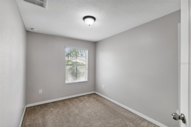 empty room with a textured ceiling and carpet floors