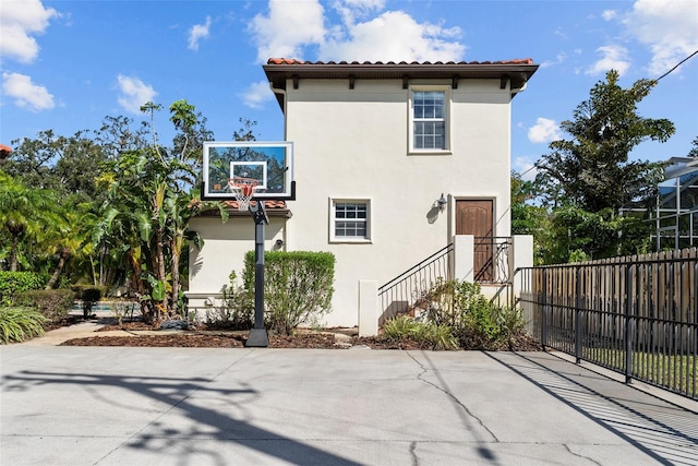 rear view of property with basketball hoop