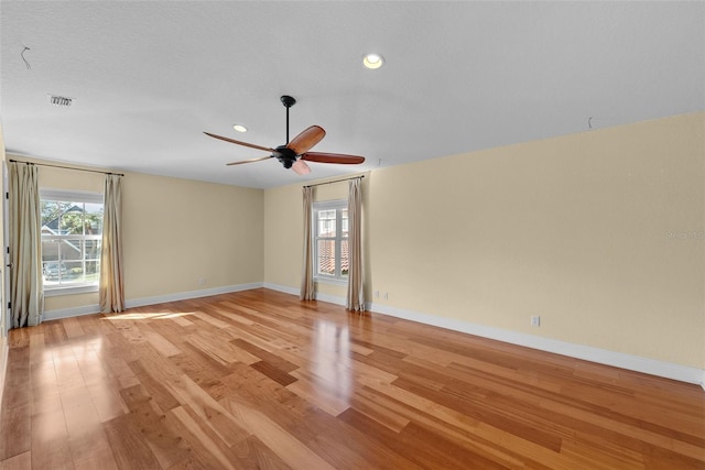 unfurnished room featuring ceiling fan, a textured ceiling, and light wood-type flooring