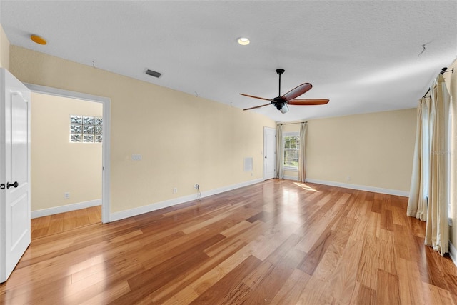 unfurnished room with ceiling fan, light hardwood / wood-style floors, and a textured ceiling