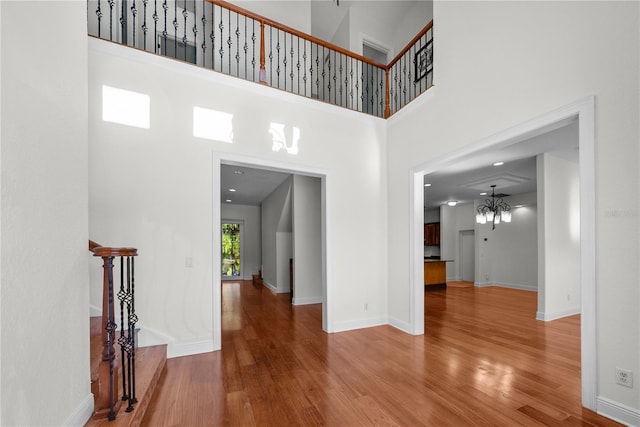 interior space with a high ceiling, an inviting chandelier, and hardwood / wood-style floors