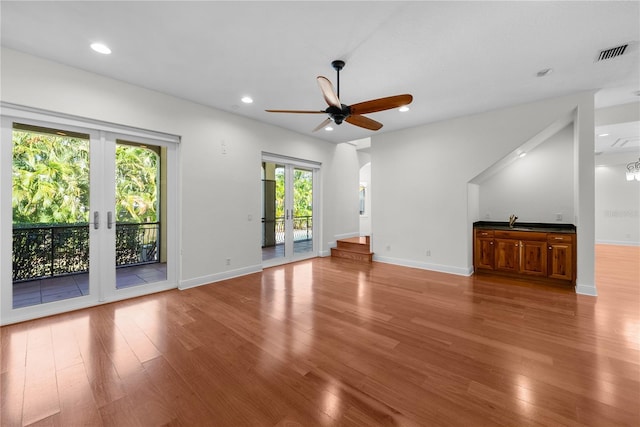 unfurnished living room with french doors, hardwood / wood-style flooring, plenty of natural light, and ceiling fan