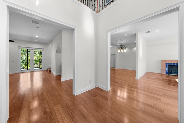 interior space with a fireplace, a chandelier, french doors, and hardwood / wood-style flooring