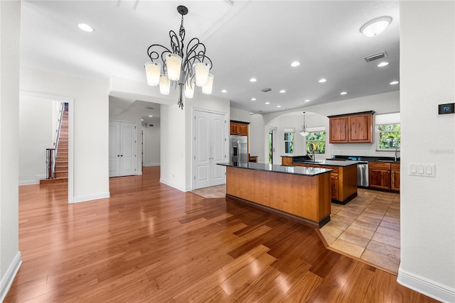 kitchen with hardwood / wood-style floors, a kitchen island, and appliances with stainless steel finishes