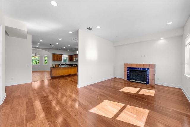 unfurnished living room featuring light wood-type flooring and a fireplace