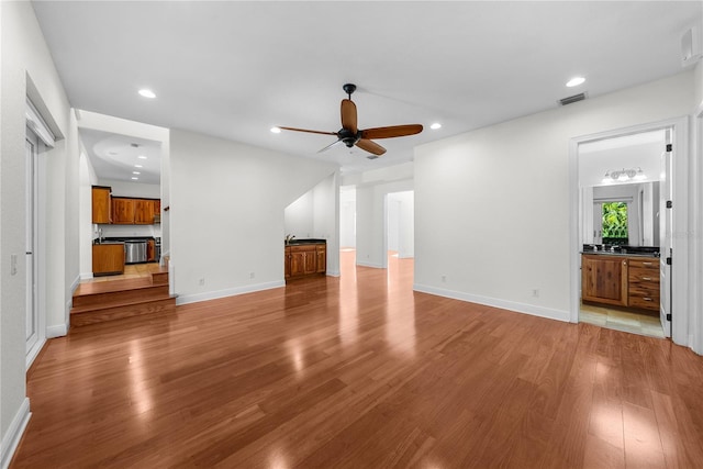 unfurnished living room featuring light hardwood / wood-style flooring and ceiling fan