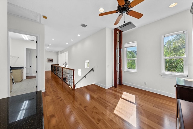 interior space with light wood-type flooring, ceiling fan, and a healthy amount of sunlight