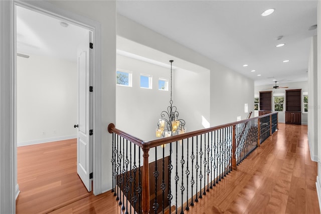 hall with plenty of natural light, a notable chandelier, and light wood-type flooring