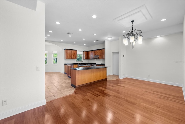 kitchen featuring sink, a chandelier, decorative light fixtures, and light wood-type flooring