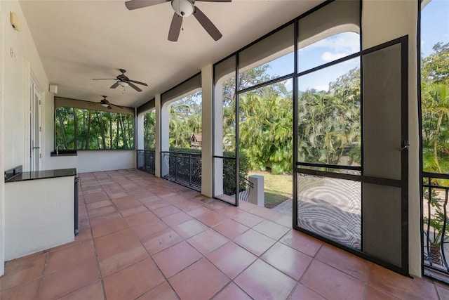 unfurnished sunroom with ceiling fan