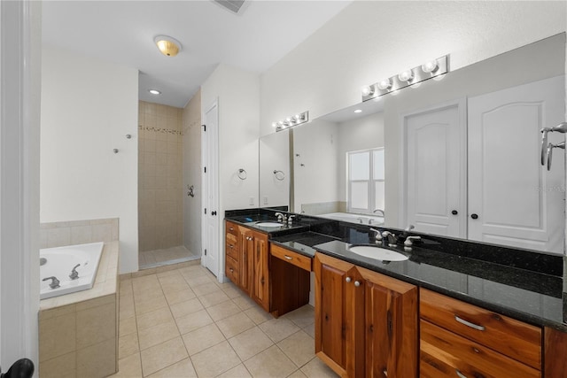 bathroom featuring plus walk in shower, vanity, and tile patterned floors