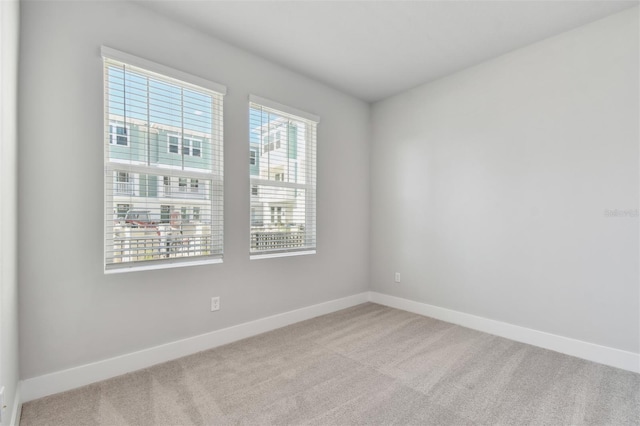 empty room featuring light carpet and plenty of natural light