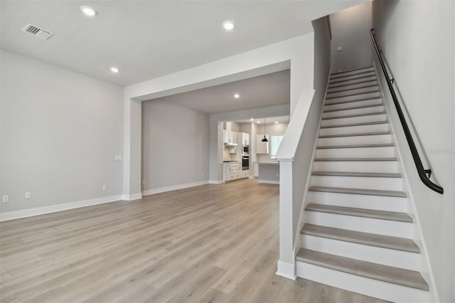 stairs featuring hardwood / wood-style floors and a textured ceiling