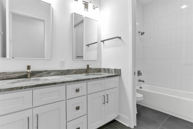 full bathroom with tile patterned flooring, vanity, tiled shower / bath combo, and toilet