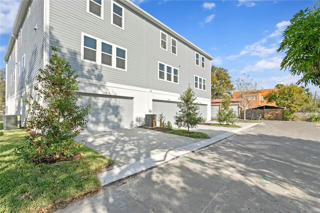 view of front of property with a garage and central air condition unit