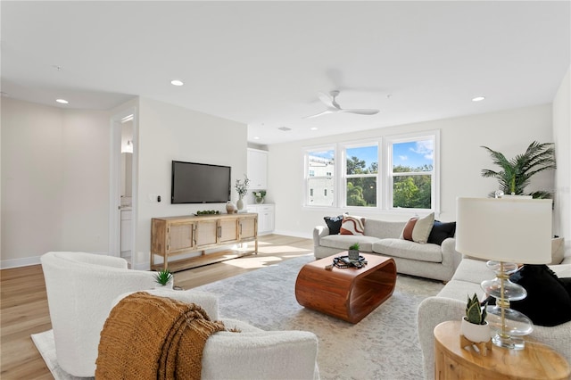 living room featuring ceiling fan and light hardwood / wood-style floors