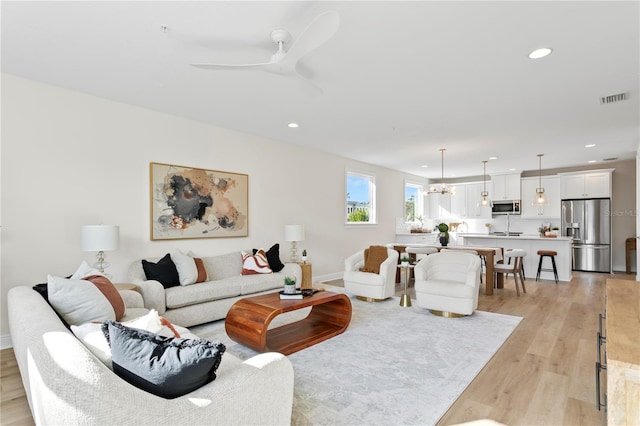 living room with ceiling fan and light hardwood / wood-style flooring