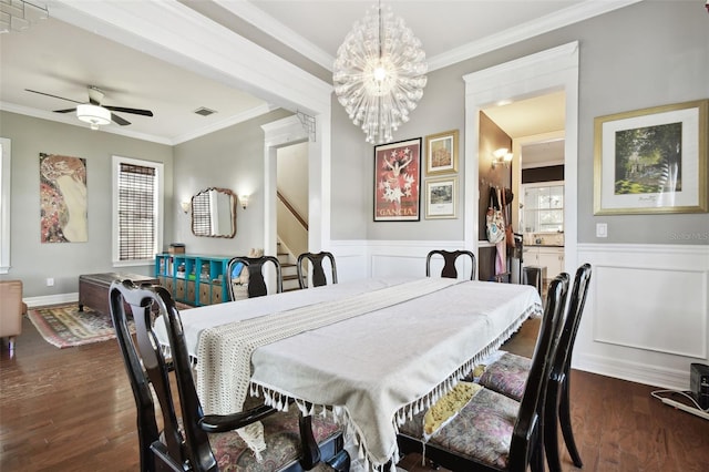 dining area featuring ornamental molding, ceiling fan with notable chandelier, and dark hardwood / wood-style flooring