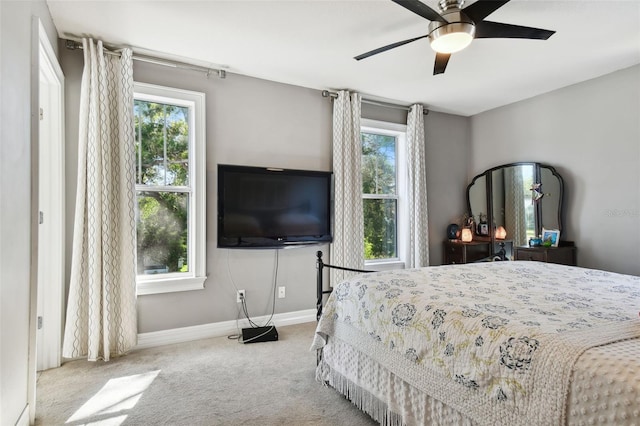 bedroom featuring light carpet, multiple windows, and ceiling fan