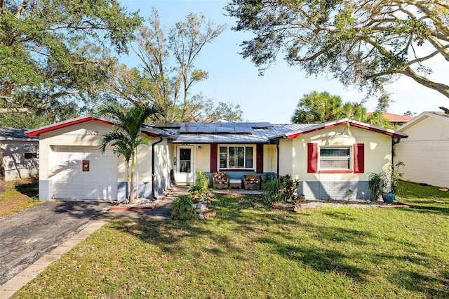 ranch-style house with a garage, a front lawn, and solar panels