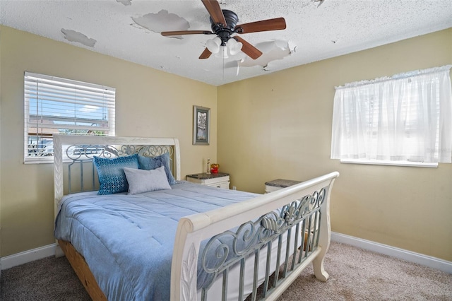 carpeted bedroom with ceiling fan and a textured ceiling