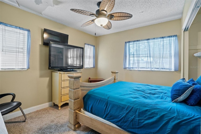 carpeted bedroom featuring a textured ceiling and ceiling fan