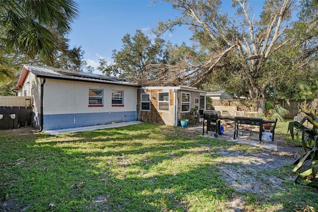 back of property with a yard and a patio area