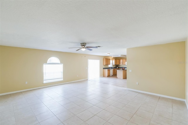 tiled empty room with a textured ceiling and ceiling fan