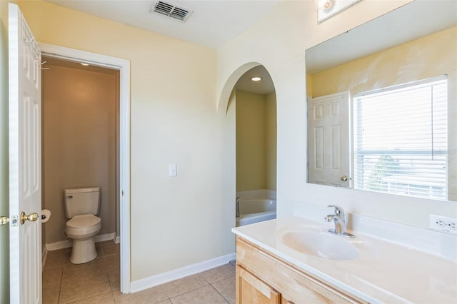 bathroom with toilet, vanity, and tile patterned floors