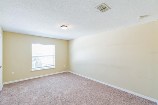 carpeted empty room featuring a textured ceiling