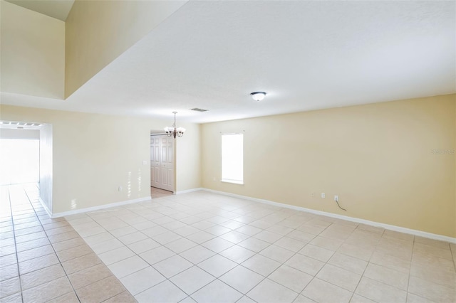 empty room with an inviting chandelier and light tile patterned floors