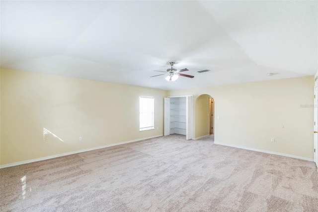 carpeted spare room featuring vaulted ceiling and ceiling fan