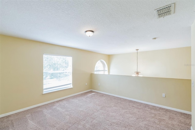 empty room with a textured ceiling and carpet floors