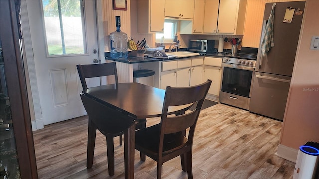 kitchen featuring cream cabinets, stainless steel appliances, light hardwood / wood-style floors, and sink