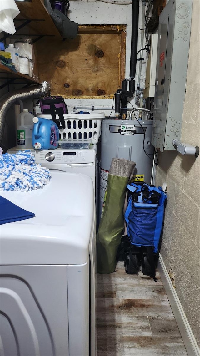 clothes washing area featuring hardwood / wood-style floors, electric panel, and washer / clothes dryer