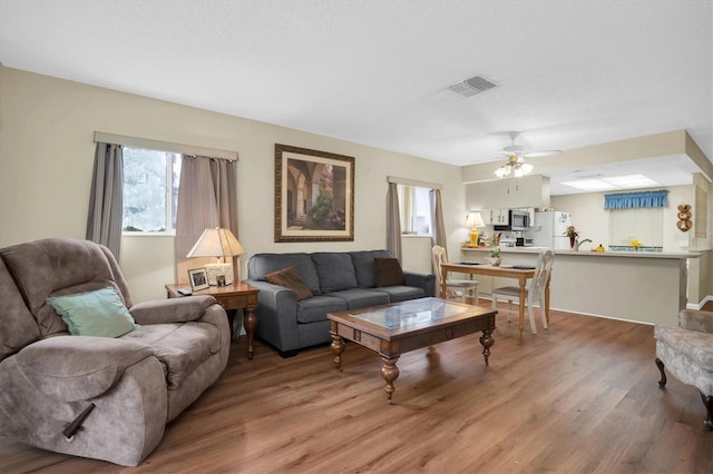 living room featuring hardwood / wood-style flooring and ceiling fan