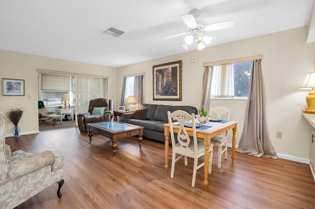 living room featuring wood-type flooring, a wealth of natural light, and ceiling fan