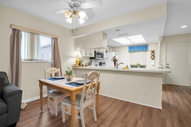 dining area with light hardwood / wood-style flooring and ceiling fan