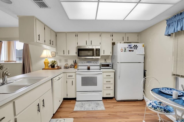 kitchen featuring light hardwood / wood-style floors, white appliances, and sink