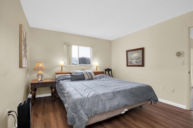 bedroom with dark wood-type flooring