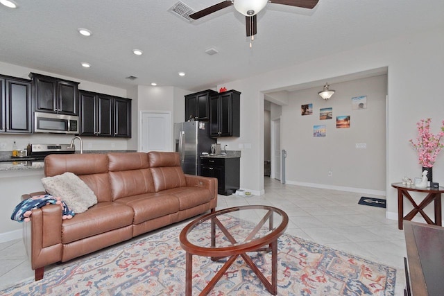 tiled living room featuring a textured ceiling and ceiling fan