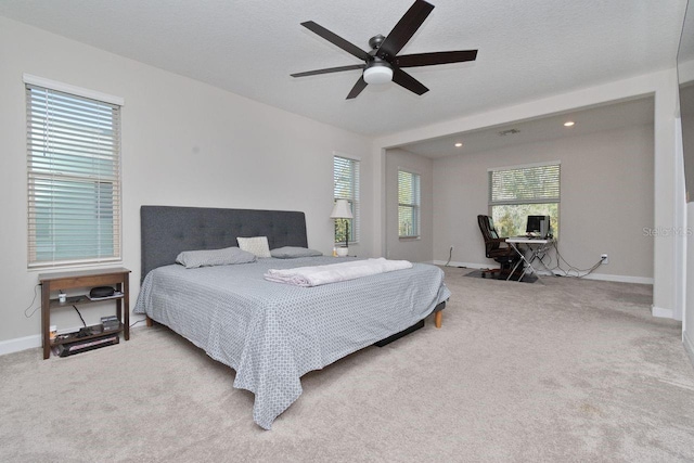 carpeted bedroom with ceiling fan and a textured ceiling