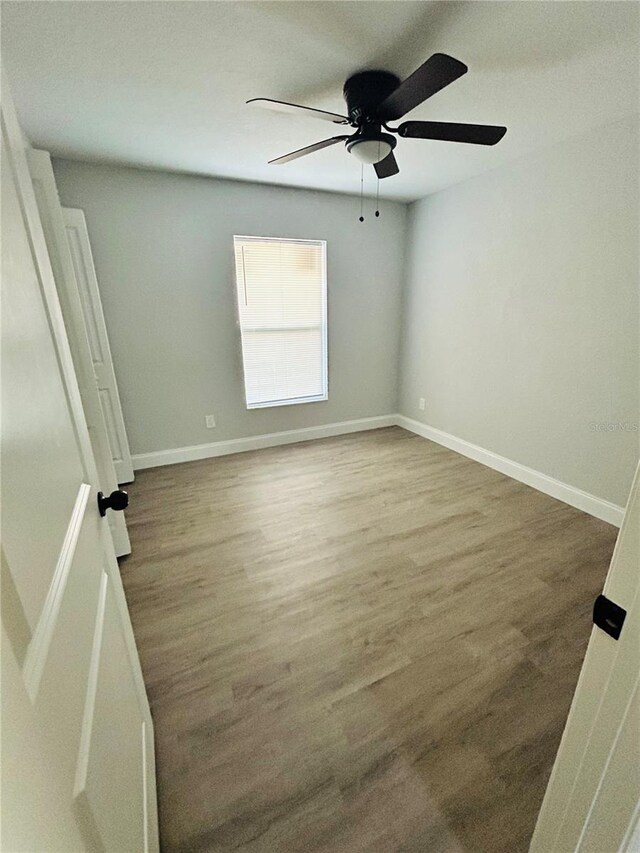 unfurnished room featuring baseboards, ceiling fan, and wood finished floors