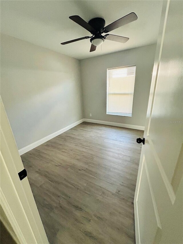 unfurnished room with baseboards, a ceiling fan, and wood finished floors