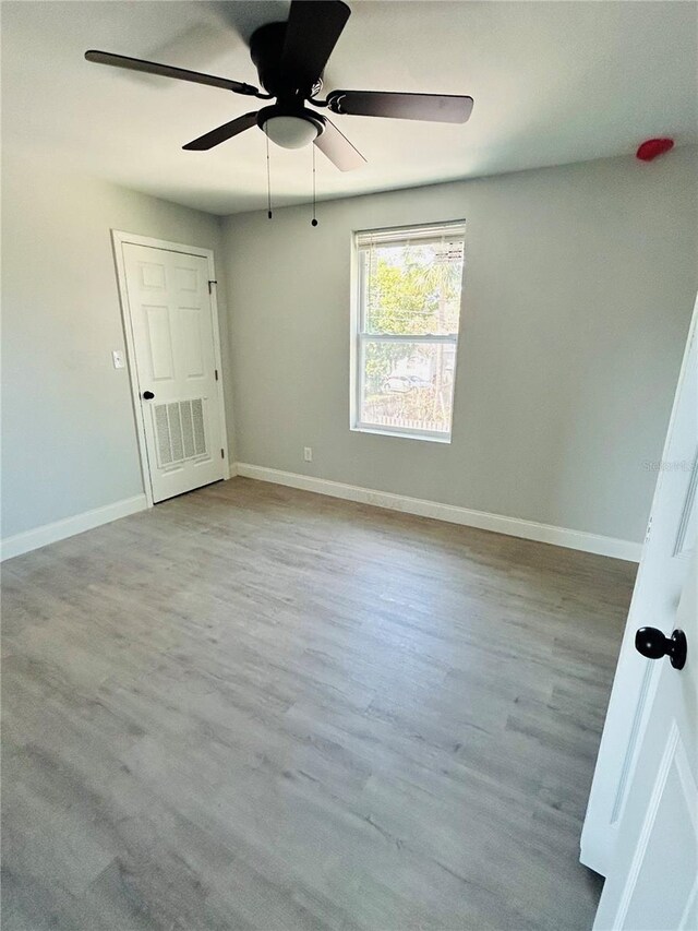 unfurnished room featuring baseboards, a ceiling fan, and wood finished floors
