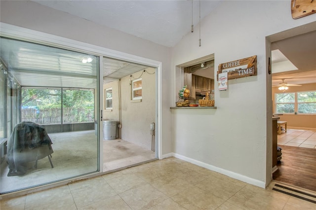 entryway featuring lofted ceiling, tile patterned flooring, and ceiling fan