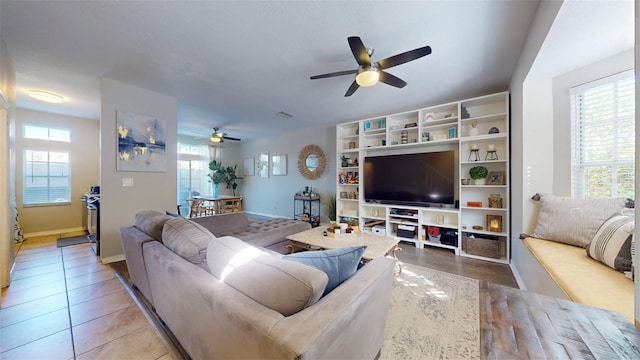 living room featuring light tile patterned floors and ceiling fan