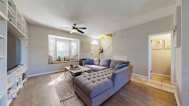 living room featuring a textured ceiling, hardwood / wood-style flooring, and ceiling fan