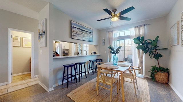 dining room with ceiling fan, sink, and hardwood / wood-style floors